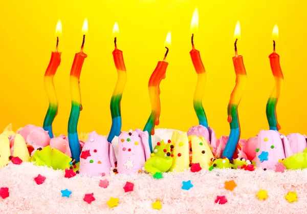 在黄色背景上的蜡烛的生日蛋糕 — 图库照片