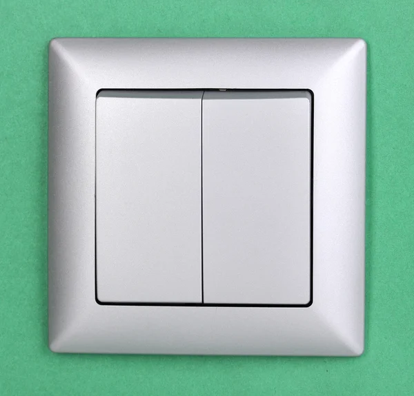 Modern light switch on green background — Stock Photo, Image