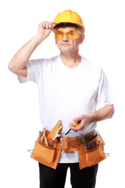 Homem construtor com construção de correia e ajusta seu capacete — Fotografia de Stock