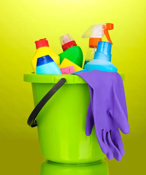 Balde com itens de limpeza em fundo verde — Fotografia de Stock