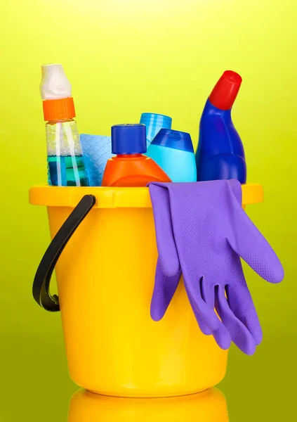 Hink med rengöring objekt på grön bakgrund — Stockfoto