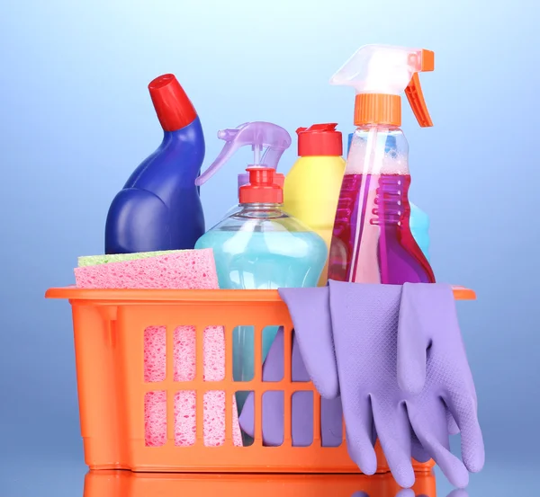 Basket with cleaning items on blue background — Stock Photo, Image