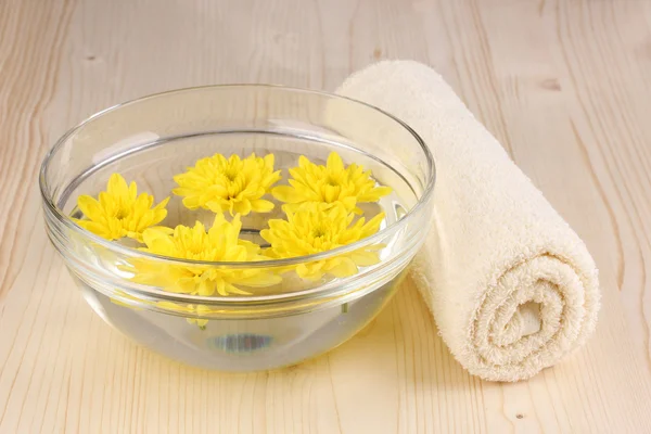 Kom met gele bloemen, spa instellen op houten achtergrond — Stockfoto