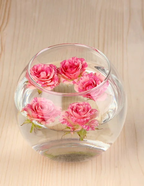 Vaso com rosas em fundo de madeira — Fotografia de Stock