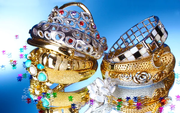 Piękne srebrne i złote bransoletki i pierścień na niebieskim tle — Zdjęcie stockowe