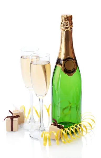 Glas och flaska champagne, gåvor och serpentine isolerad på en vit — Stockfoto