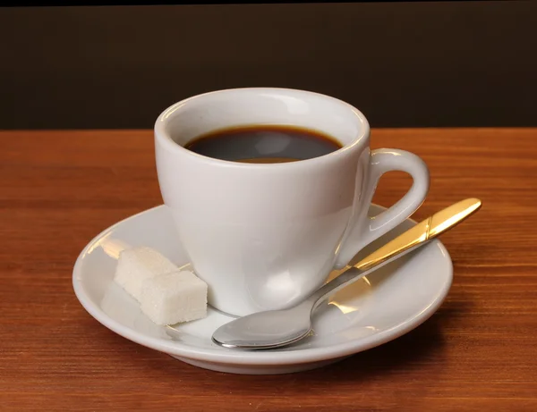 Kaffeetasse auf Holztisch auf braunem Hintergrund — Stockfoto