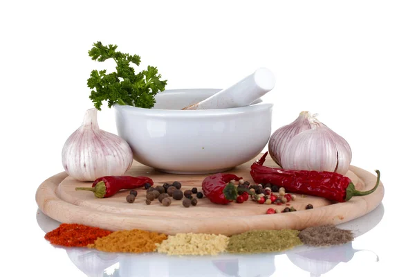 Composition of White mortar and pestle with spice and vegetables on cutting board isolated on white — Stock Photo, Image