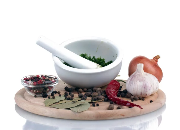Zusammensetzung aus weißem Mörser und Stößel mit Gemüse und Gewürzen auf Schneidebrett isoliert auf weißem — Stockfoto