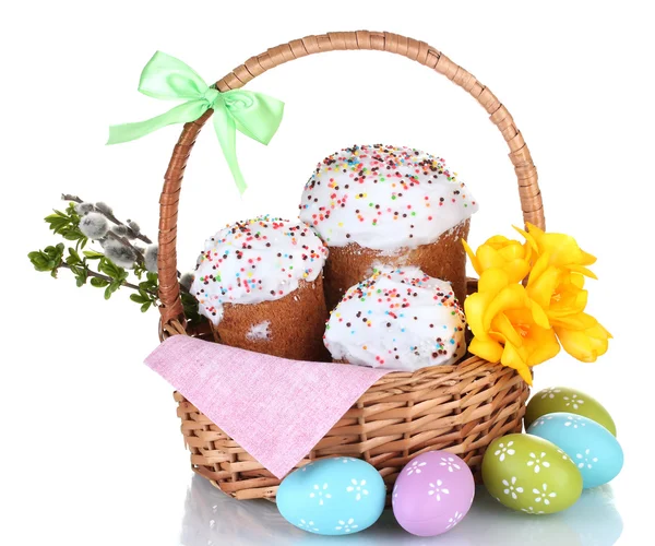 Hermosos pasteles de Pascua en cesta, huevos coloridos y flores aisladas en blanco —  Fotos de Stock