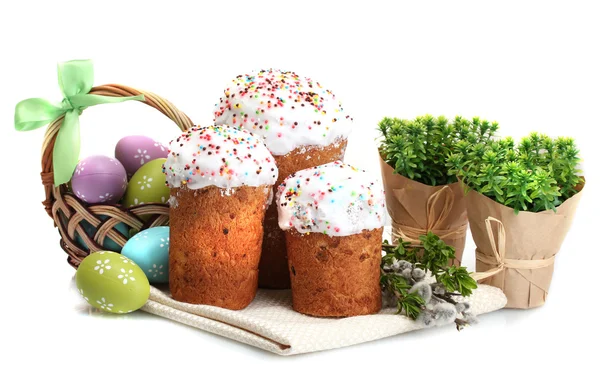 Красиві великодні торти, різнокольорові яйця в кошику і гілочки вівчарки ізольовані на білому — стокове фото