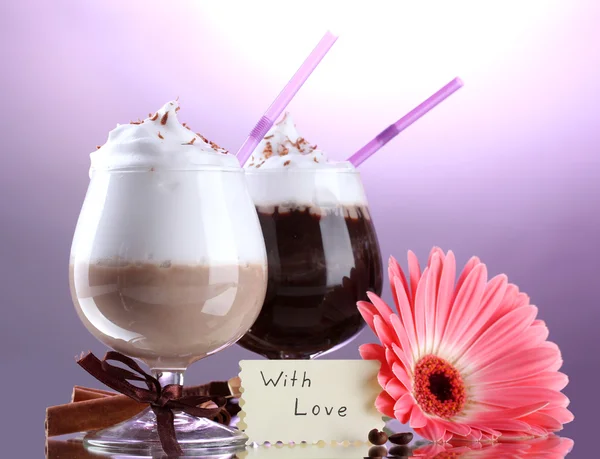Glasses of coffee cocktail and gerbera flower on violet background — Stock Photo, Image
