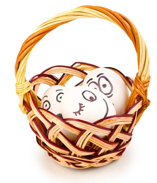 Huevos blancos con caras divertidas en cesta aislada sobre blanco —  Fotos de Stock