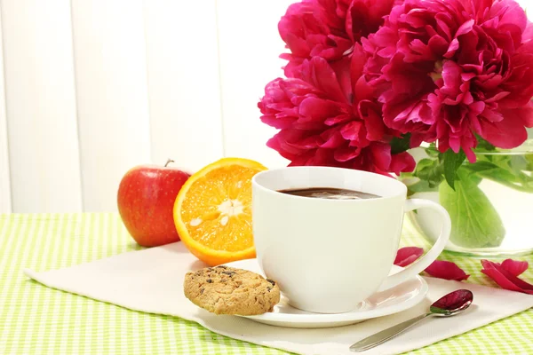 Kubek gorącej czekolady, jabłko, pomarańcza, ciasteczka i kwiaty na stole w kawiarni — Zdjęcie stockowe