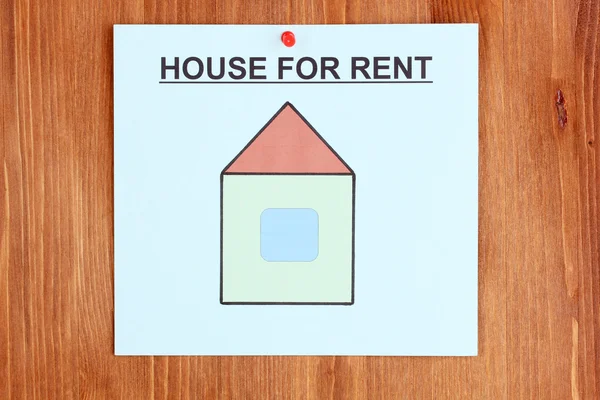 Poster about renting the house on wooden background — Stock Photo, Image