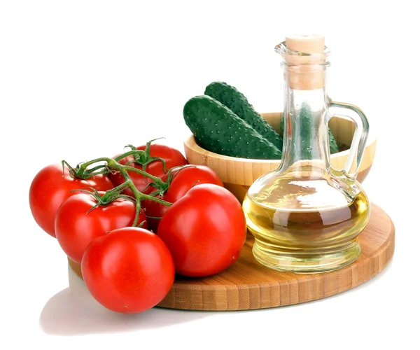 Tomatoes and cucumbers with oil on wooden board isolated on white — Stock Photo, Image