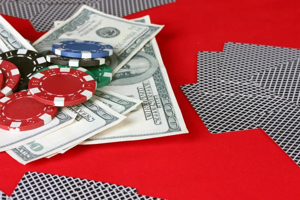 Jouer aux cartes, jetons de poker et dollars sur une table rouge — Photo
