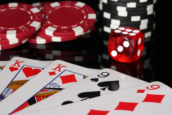 Полный дом фишек для покера и кости на черном фоне крупным планом — стоковое фото