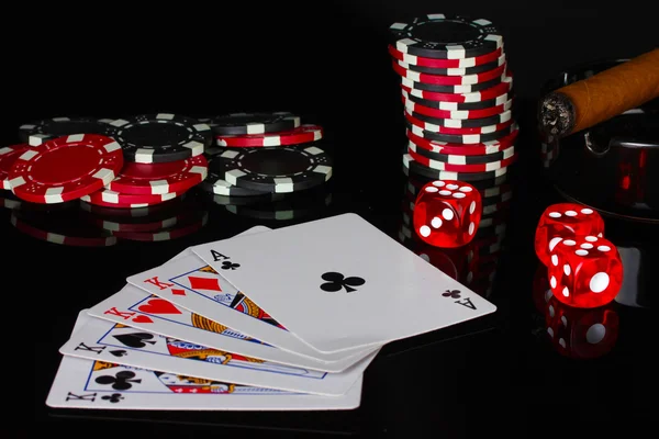 Quatre d'un genre avec des jetons de poker et des dés sur fond noir — Photo