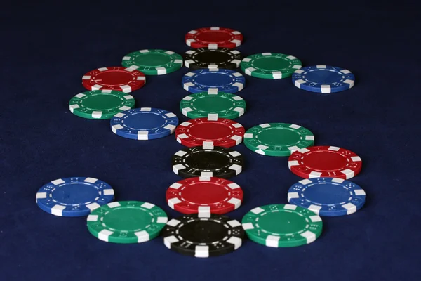 Poker chips in the form of dollars on a blue table — Stock Photo, Image
