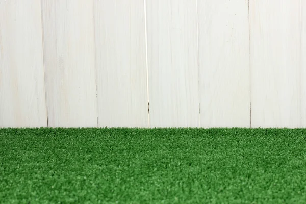Der Hintergrund von grünem Gras vor der weißen Scheune — Stockfoto