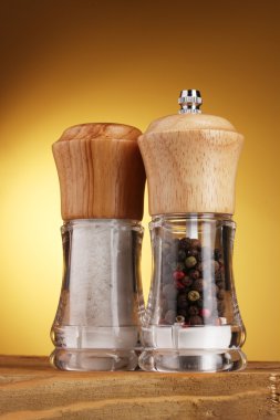 Salt and pepper mills on yellow clipart