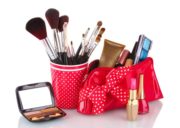 Rött glas med borstar och makeup väska med kosmetika isolerad på vit — Stockfoto