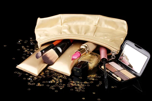 Schöne goldene Make-up-Tasche und Kosmetik isoliert auf schwarz — Stockfoto