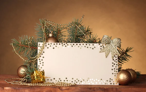Чистая открытка, рождественские шары и елка на деревянном столе на коричневом фоне — стоковое фото