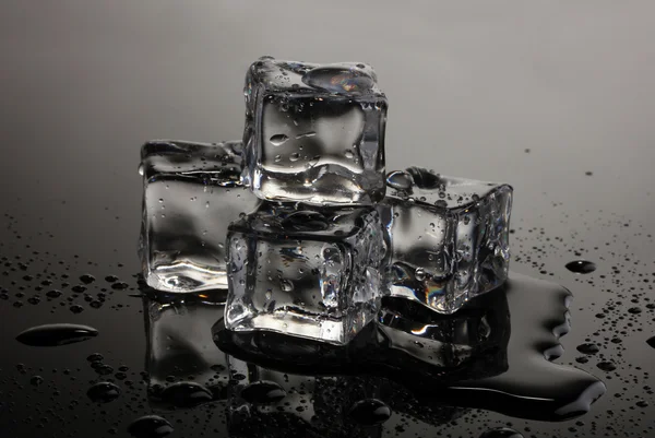 Танення кубиків льоду на сірому фоні — стокове фото