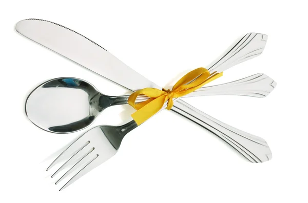 Gümüş çatal ve kaşık, bıçak üzerinde beyaz izole sarı kurdele ile bağlanmış — Stok fotoğraf