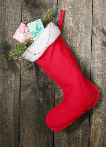 Julstrumpa med presenter på trä bakgrund Royaltyfria Stockbilder