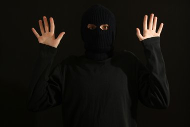 Surrounded and trapped bandit in black mask isolated on black clipart