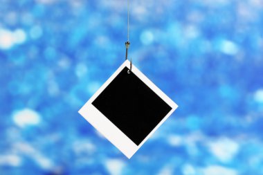 Photo on fish hook on blue background clipart