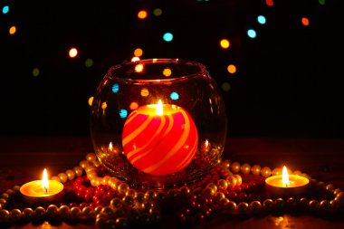 Wonderful composition with candle in glass on wooden table on bright background clipart