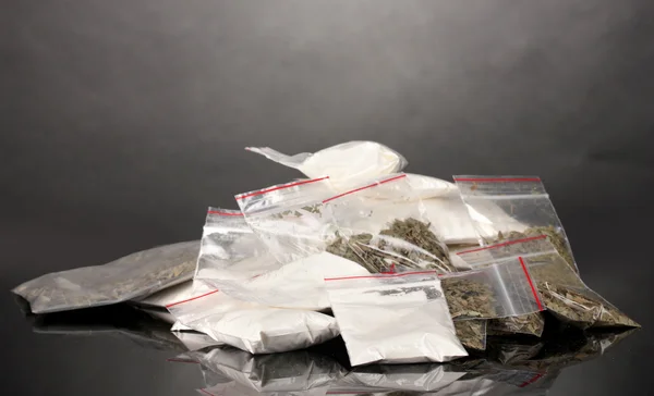 Cocaïne en marihuana in pakketten op grijze achtergrond — Stockfoto