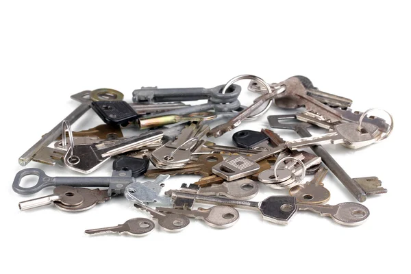 Spousta kovových klíčů izolovaných na bílém — Stock fotografie