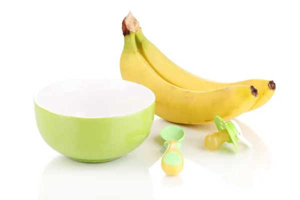 Placa de bebé y cuchara con plátanos y muñeco de bebé aislado en blanco —  Fotos de Stock