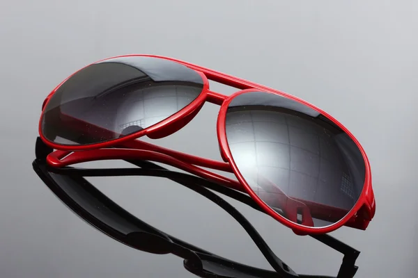 Mulheres glamourosas óculos de sol vermelhos no fundo cinza — Fotografia de Stock