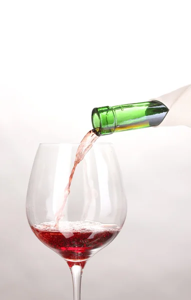 Pouring wine into wineglass isolated on white — Stock Photo, Image