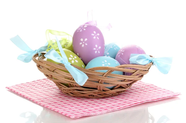 Huevos coloridos de Pascua en cesta en servilleta aislada en blanco —  Fotos de Stock