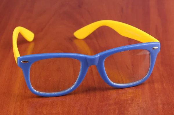 Krásné barevné brýle na dřevěné pozadí — Stock fotografie
