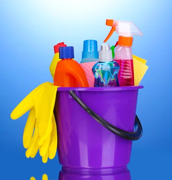 Emmer met reiniging items op blauwe achtergrond — Stockfoto