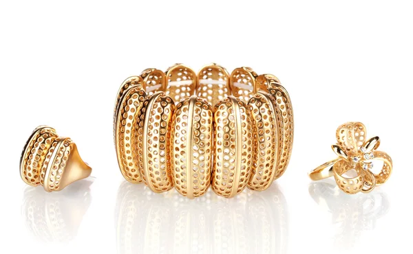 Bela pulseira dourada e anéis isolados em branco — Fotografia de Stock