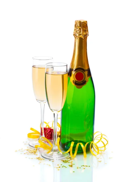 Glazen en een fles champagne, geschenken en serpentine geïsoleerd op een witte — Stockfoto
