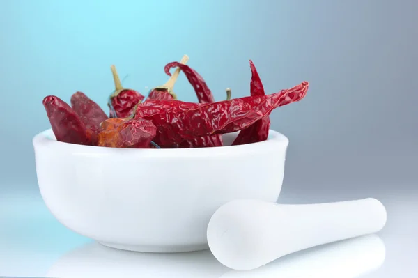 stock image White mortar and pestle with red peppers