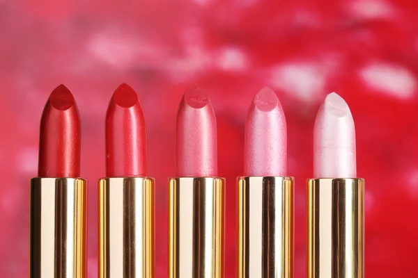 Beautiful lipsticks on red background — Stock Photo, Image