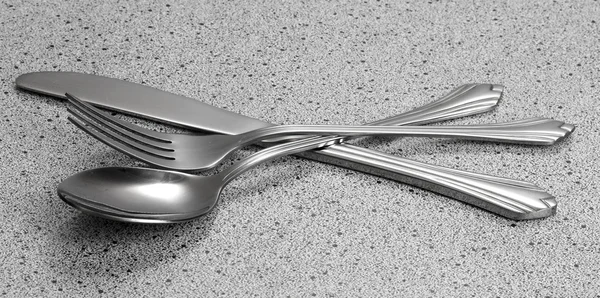 Forchetta, cucchiaio e coltello sul tavolo di marmo — Foto Stock