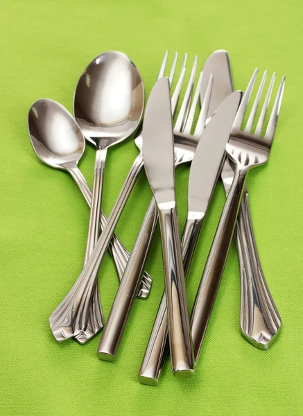 フォーク、スプーン、ナイフ、緑のテーブル クロスで — ストック写真