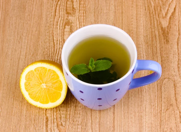 Chá de hortelã com folha de hortelã e limão no fundo de madeira — Fotografia de Stock